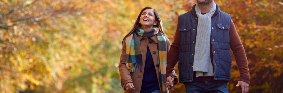 couple walking holding hands in autumn