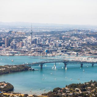 Aerial view of Auckland city featuring ocean and harbour bridge