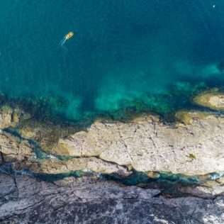 aerial view of a boat in the water around the coromandel