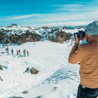 man taking photo in snow