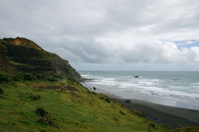 view of hill with wild black sand beach