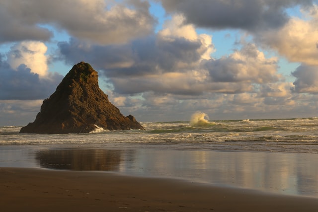 rock formation on black sand karekare beach