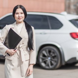 woman holding folder next to car