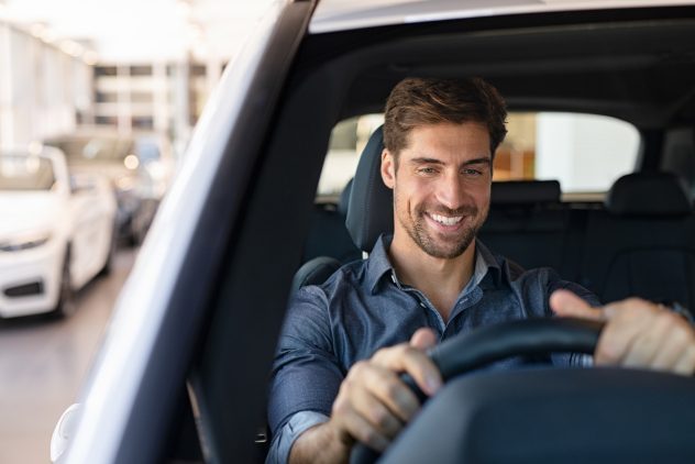 man sitting in driver seat of his car