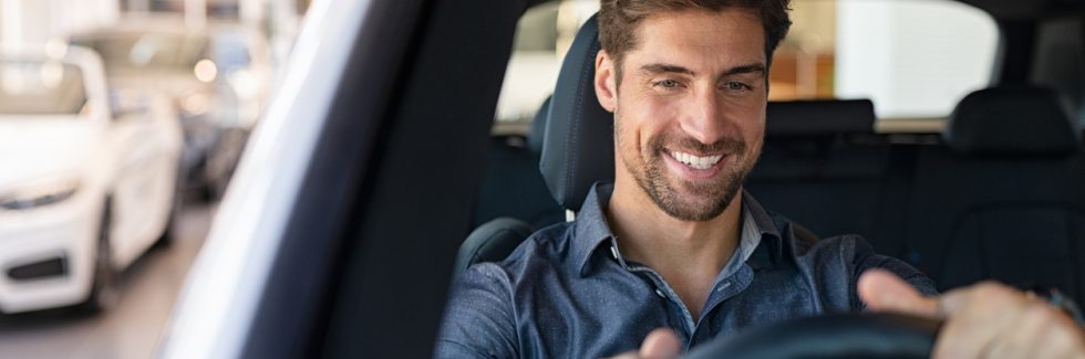 man sitting in driver seat of his car