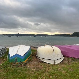 Upturned boats on beach at sunrise