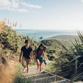 Woman and man enjoying the scenic Omanawanui nature track in west Auckland